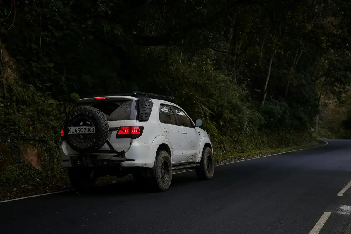 White suv driving down a winding road.